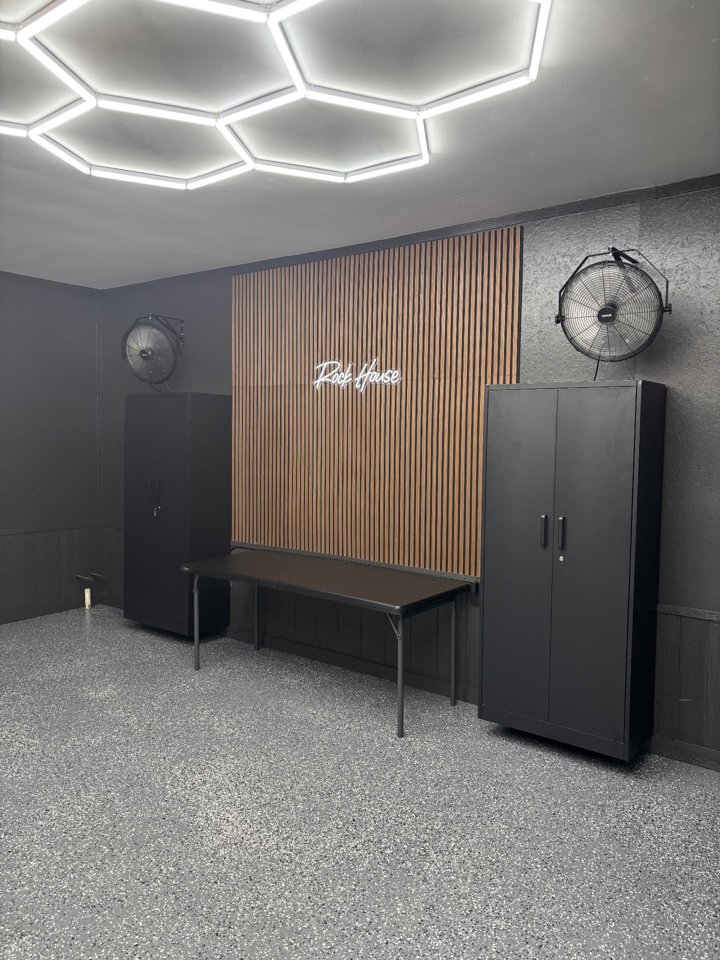 Wood slat feature wall with neon signage inside the Rock House Garage build