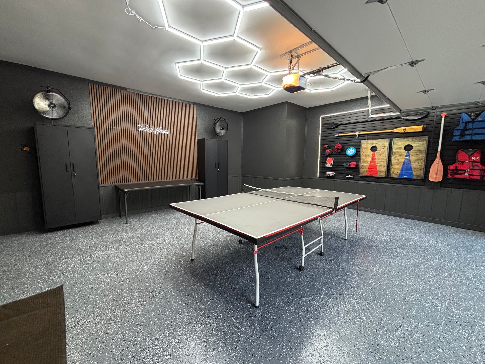Rock House Garage transformation with hex LED lighting, slat feature wall, and flake epoxy floor